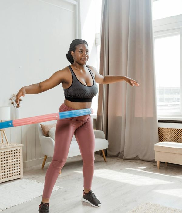Energetic woman smiling during a light cardio workout session at home.